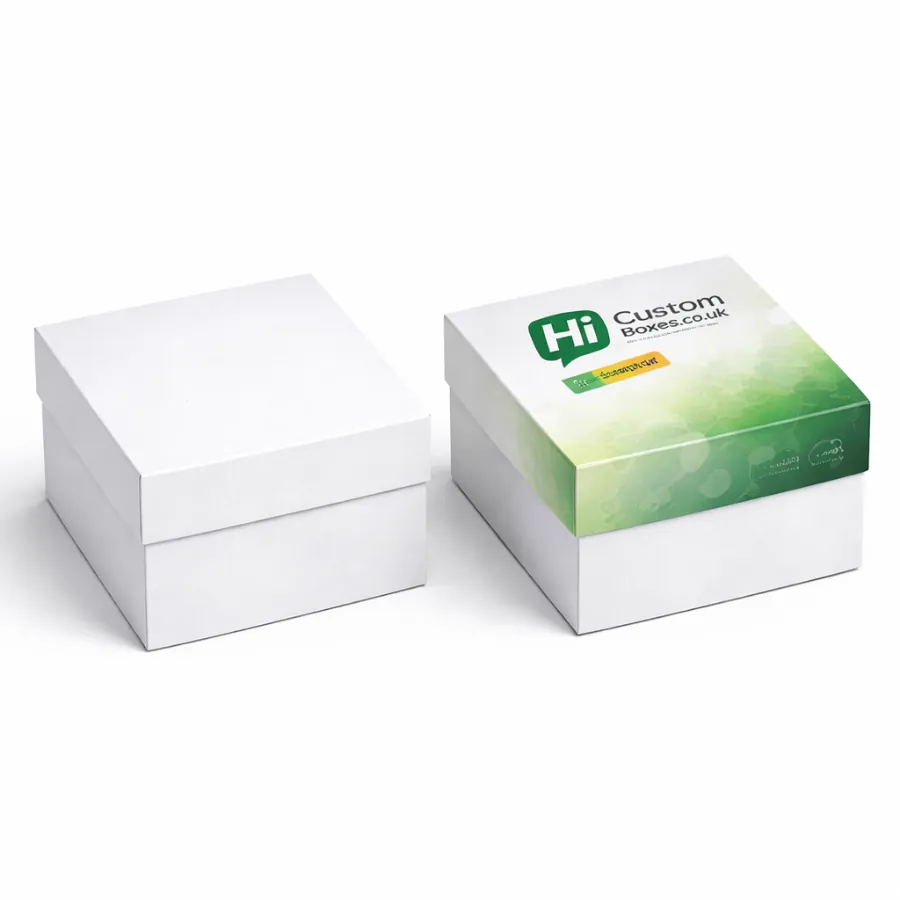 Two square luxury boxes with lids- one plain white and one with green branded graphics- class=